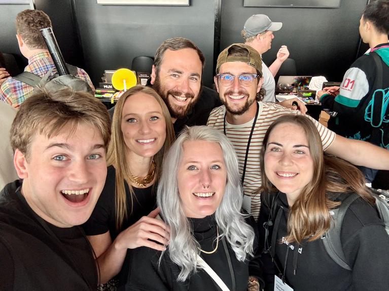 A bunch of people (including Christina) at a dev event smiling and having a great time