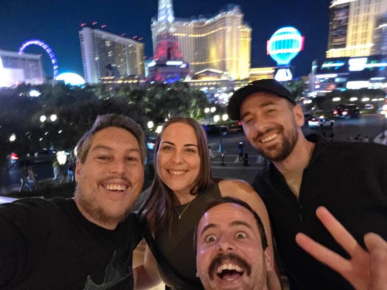 Christina and coworkers smile in front of the Vegas strip